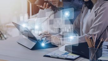 Big data analytics and business intelligence concept with chart and graph icons on a digital screen interface and a businessman hand in background